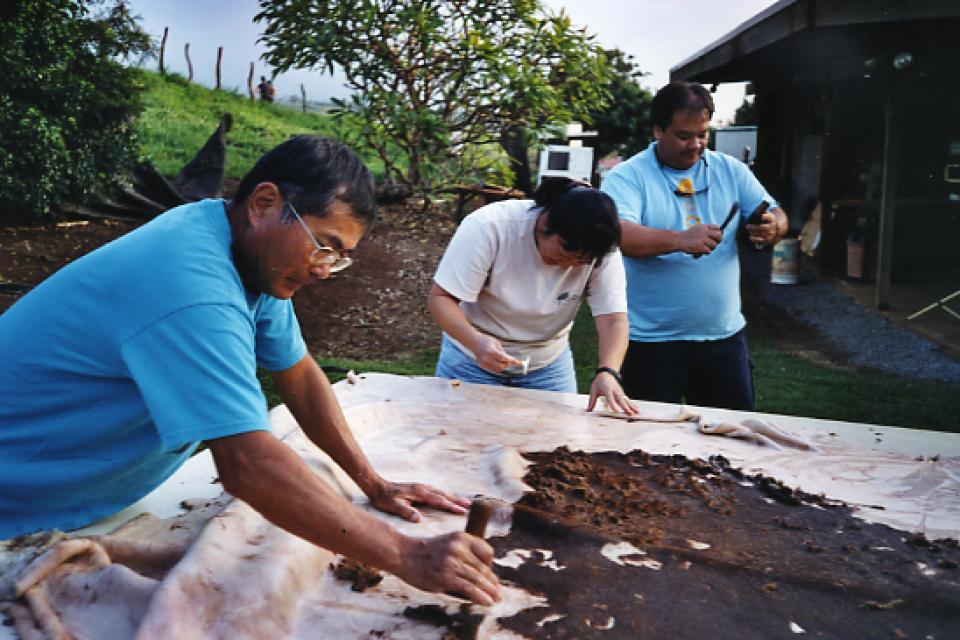 Three taiko members remove hair from a fresh cowhide to be used for a 5-foot-diameter hira-daiko
